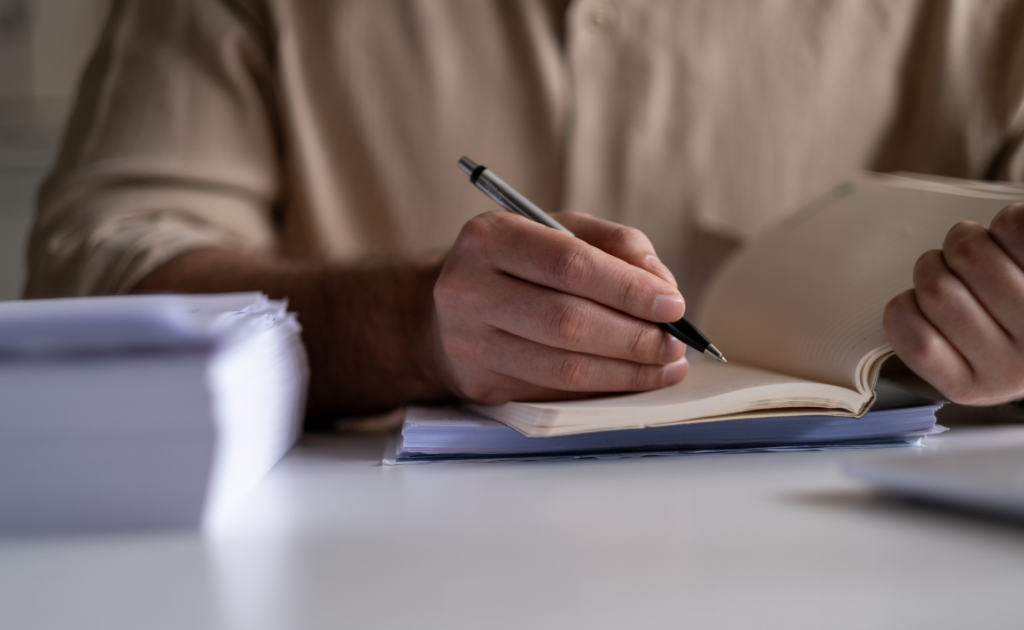 Hands holding pen and notebook