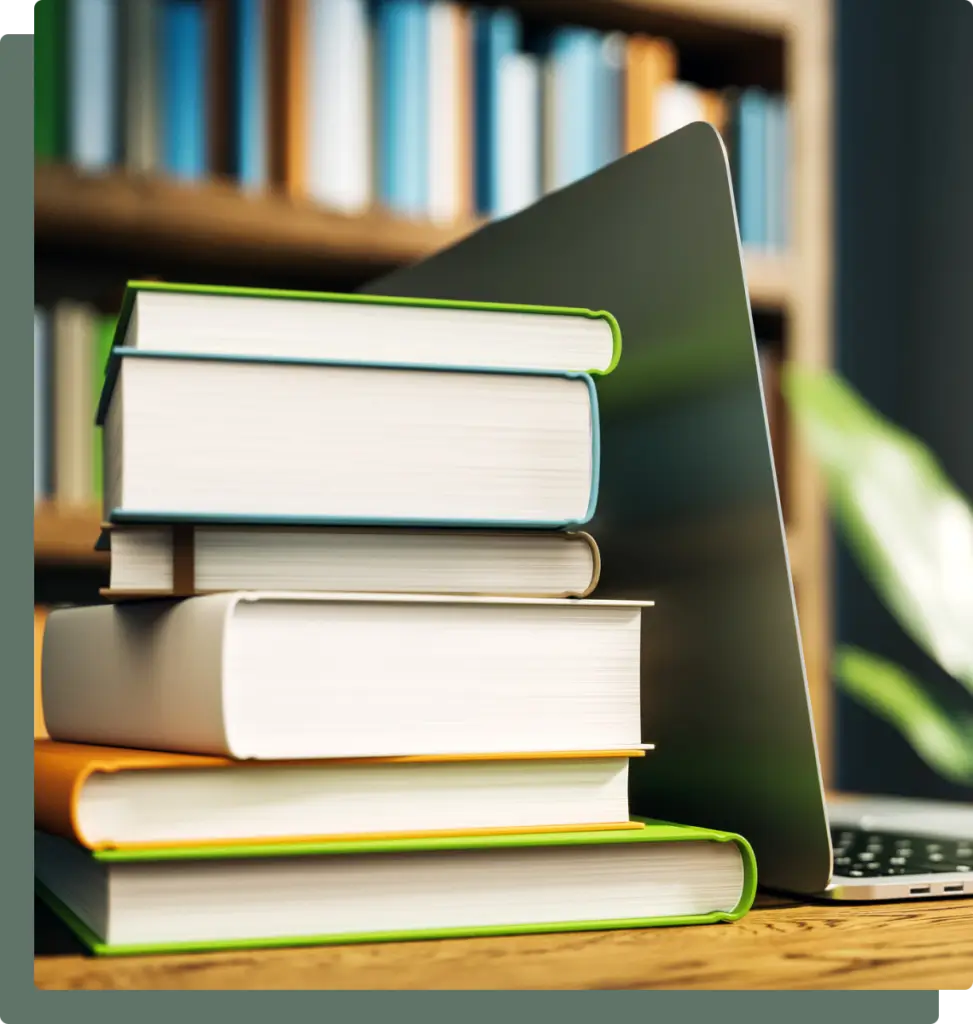 Stack of books beside a laptop